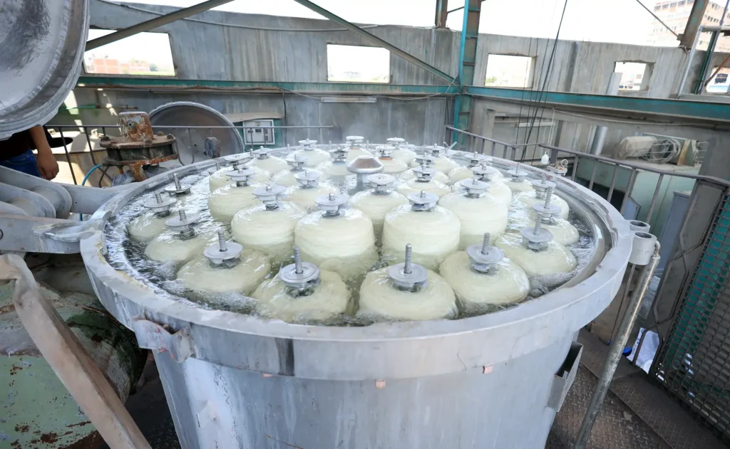 Bleaching linen and flax yarn spools in industrial dyeing machine at El Nawawy Company factory