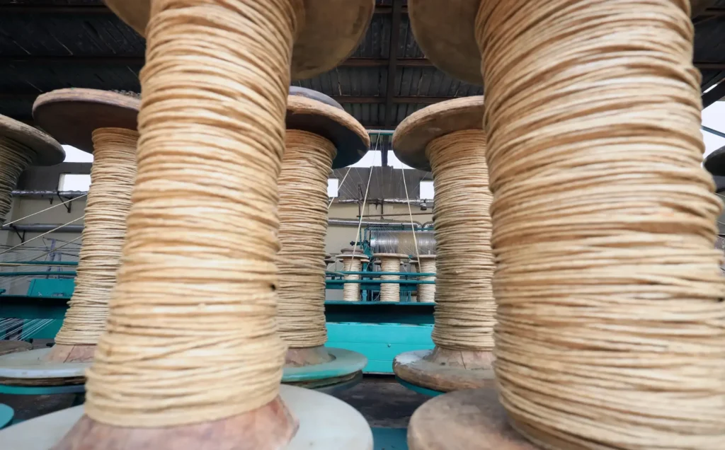 Large linen yarn spools after polishing process with wax finish at El Nawawy Company factory
