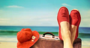 Füße in Stoffschuhen aus Naturfasern vor Strand und Meer
