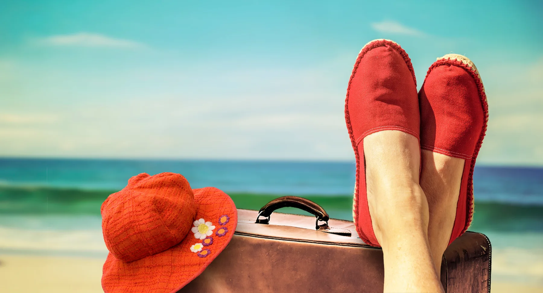 Füße in Stoffschuhen aus Naturfasern vor Strand und Meer